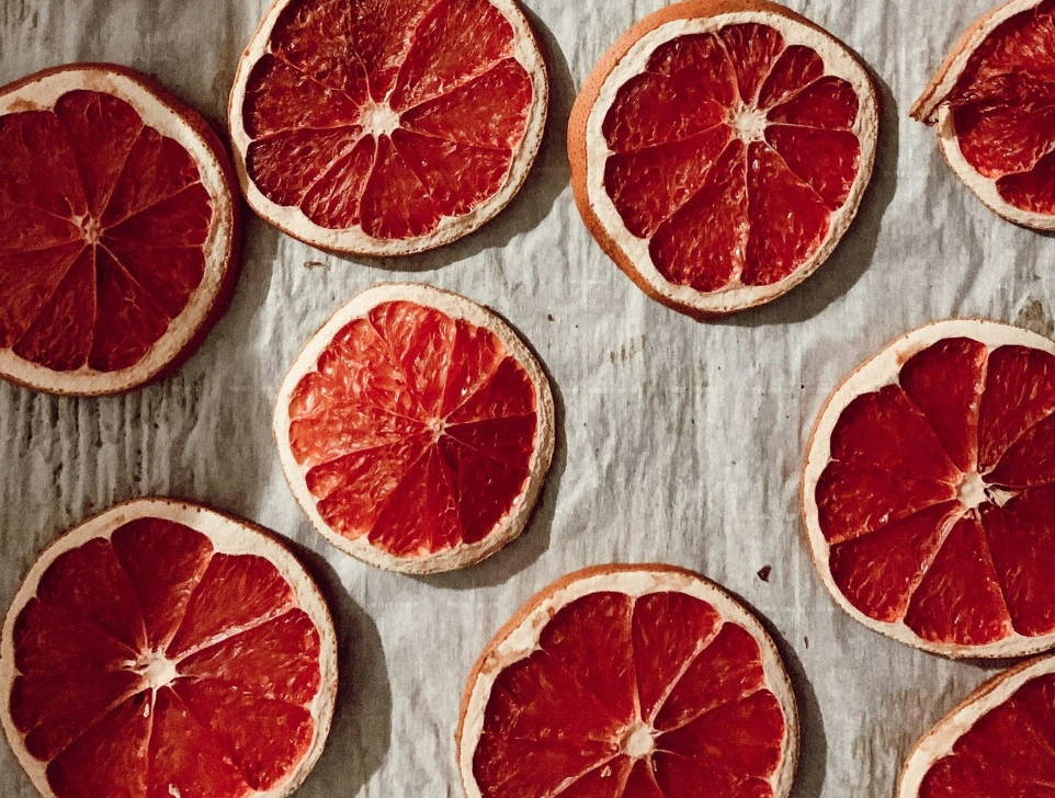 sliced orange fruit on white and blue textile